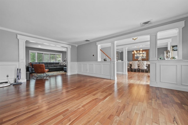 25 Bellwood Dr, New City, NY 10956 - living area with ornate columns, light wood-style flooring, crown molding, a decorative wall, and wainscoting