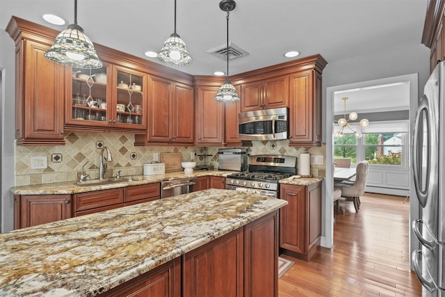 25 Bellwood Dr, New City, NY 10956 - kitchen with stainless steel appliances, light stone countertops, light wood-style floors, glass insert cabinets, and pendant lighting