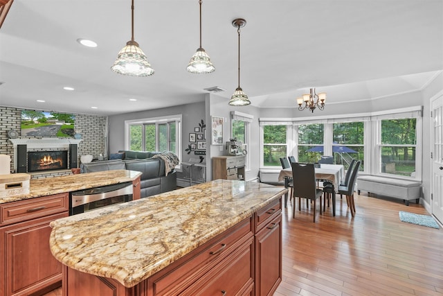 25 Bellwood Dr, New City, NY 10956 - kitchen with open floor plan, a fireplace, brown cabinets, a chandelier, and recessed lighting