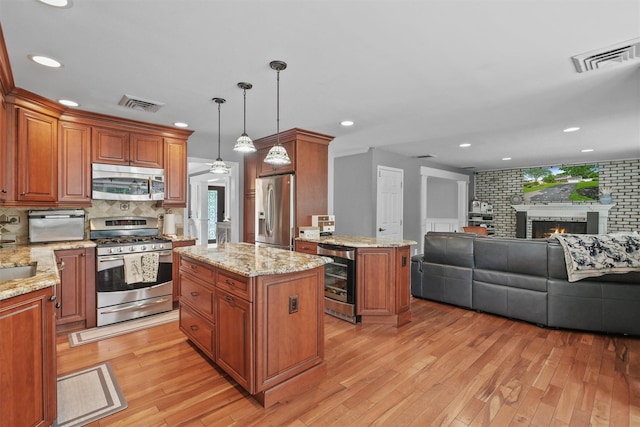 25 Bellwood Dr, New City, NY 10956 - kitchen featuring stainless steel appliances, beverage cooler, open floor plan, a kitchen island, and light wood-style floors