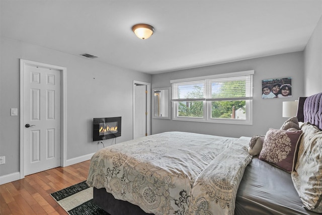 25 Bellwood Dr, New City, NY 10956 - bedroom with wood-type flooring and a glass covered fireplace