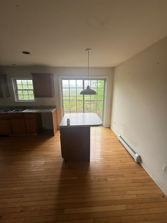 48 Patmore Ave, Yonkers, NY 10710 - kitchen with baseboard heating, light wood finished floors, decorative light fixtures, and a kitchen island
