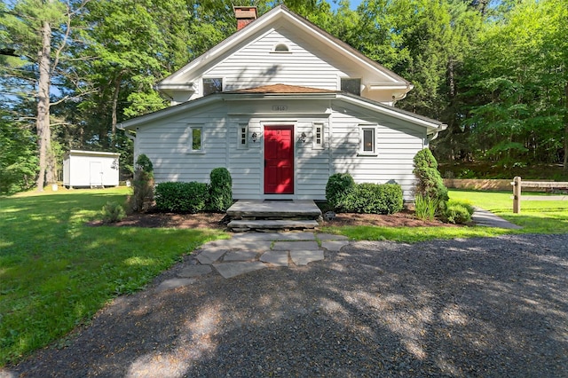 62 Guymard Tpke, Godeffroy, NY 12729 - view of front facade with a chimney, a front lawn, and an outdoor structure