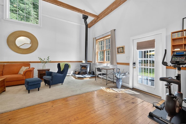 62 Guymard Tpke, Godeffroy, NY 12729 - living room with a wood stove, high vaulted ceiling, beam ceiling, hardwood / wood-style floors, and a baseboard heating unit