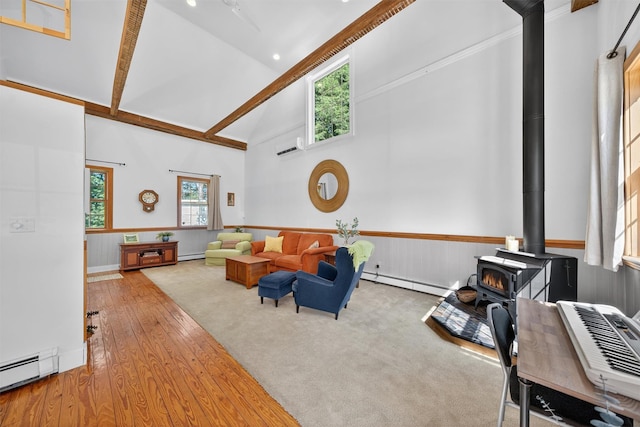 62 Guymard Tpke, Godeffroy, NY 12729 - living area featuring high vaulted ceiling, a wood stove, a wainscoted wall, baseboard heating, and wood finished floors