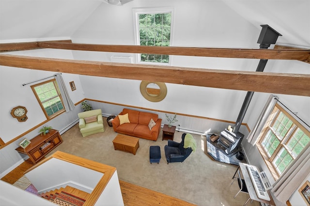 62 Guymard Tpke, Godeffroy, NY 12729 - carpeted living area with lofted ceiling, a wood stove, a baseboard heating unit, and plenty of natural light