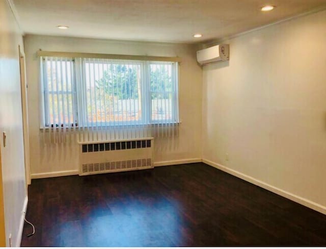 5-39 117th St, Flushing, NY 11356 - empty room with radiator, an AC wall unit, wood finished floors, and recessed lighting