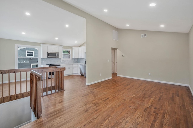12 Bay Ave, Lake Ronkonkoma, NY 11779 - unfurnished living room featuring recessed lighting, lofted ceiling, and light wood-style flooring