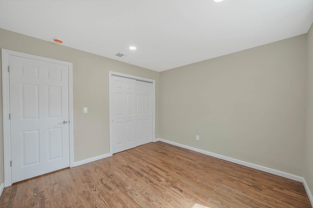 12 Bay Ave, Lake Ronkonkoma, NY 11779 - unfurnished bedroom featuring light wood-type flooring, a closet, and recessed lighting