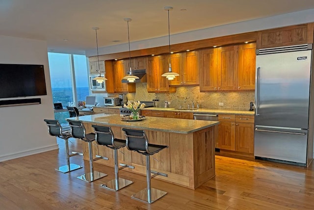 5 Renaissance Sq Unit Ph6C, White Plains, NY 10601 - kitchen with built in appliances, a kitchen island, and brown cabinets