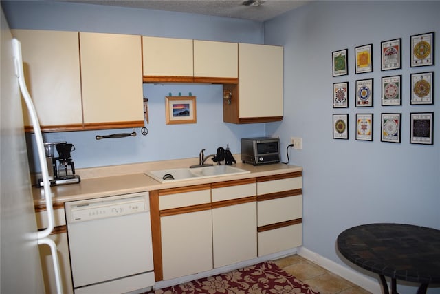 3905 Wild Berry Ct Unit 6C, Poughkeepsie, NY 12603 - kitchen featuring white dishwasher, light countertops, freestanding refrigerator, light tile patterned flooring, and cream cabinets