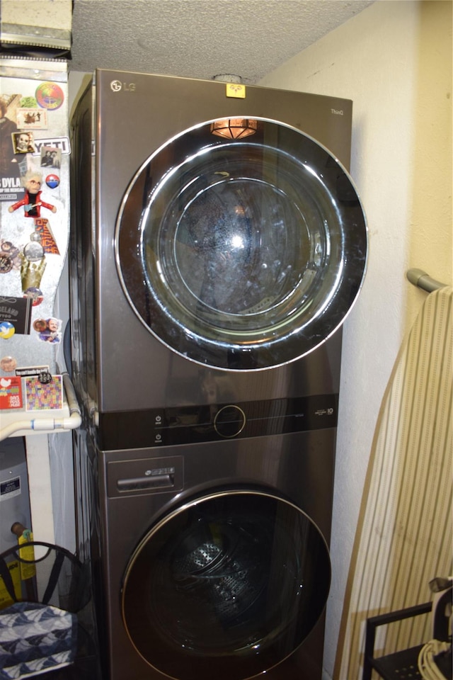 3905 Wild Berry Ct Unit 6C, Poughkeepsie, NY 12603 - washroom featuring stacked washer and clothes dryer and a textured ceiling