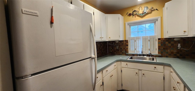 76 Gooseberry Rd, Mastic Beach, NY 11951 - kitchen with freestanding refrigerator, decorative backsplash, light countertops, and white cabinets