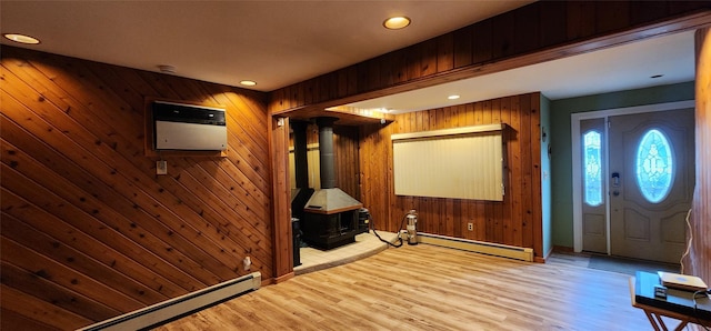 76 Gooseberry Rd, Mastic Beach, NY 11951 - entrance foyer with a baseboard radiator, a wood stove, wood finished floors, wood walls, and recessed lighting