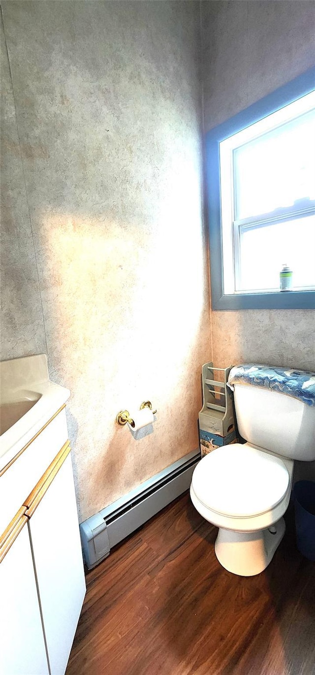 76 Gooseberry Rd, Mastic Beach, NY 11951 - half bathroom featuring a baseboard radiator, vanity, and wood finished floors