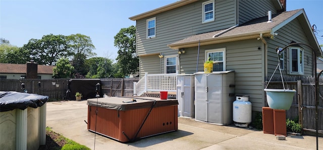 76 Gooseberry Rd, Mastic Beach, NY 11951 - back of property featuring a hot tub, a patio area, a fenced backyard, and roof with shingles