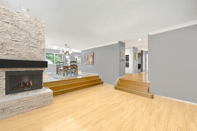 76 Boulder Ridge Rd, Scarsdale, NY 10583 - unfurnished living room featuring crown molding, wood finished floors, a stone fireplace, and a chandelier