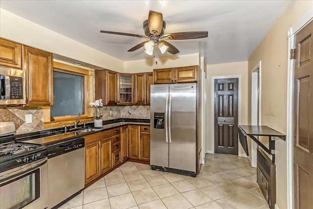 165 Wheeler Ave, Valley Stream, NY 11580 - kitchen featuring appliances with stainless steel finishes, brown cabinetry, ceiling fan, tasteful backsplash, and dark countertops