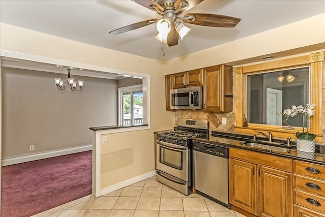 165 Wheeler Ave, Valley Stream, NY 11580 - kitchen with stainless steel appliances, dark countertops, brown cabinets, a ceiling fan, and decorative backsplash