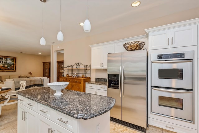 166 Country Club Dr Unit 166, Commack, NY 11725 - kitchen with appliances with stainless steel finishes, white cabinets, dark stone countertops, a center island, and hanging light fixtures