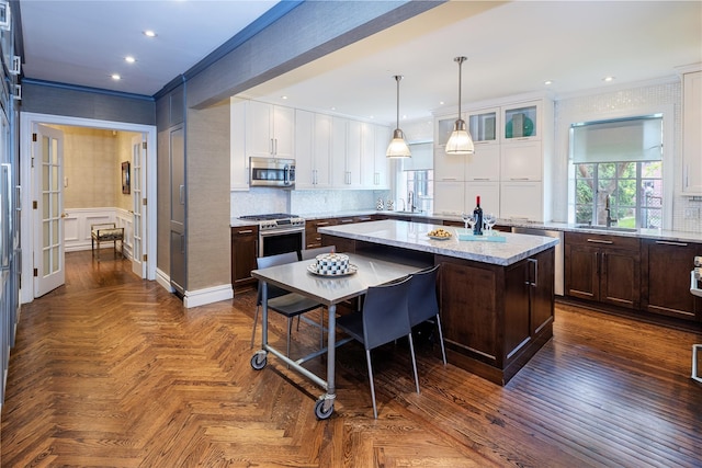 3001 Henry Hudson Pkwy Unit 1Fg, Bronx, NY 10463 - kitchen with stainless steel appliances, a center island, white cabinetry, healthy amount of natural light, and crown molding