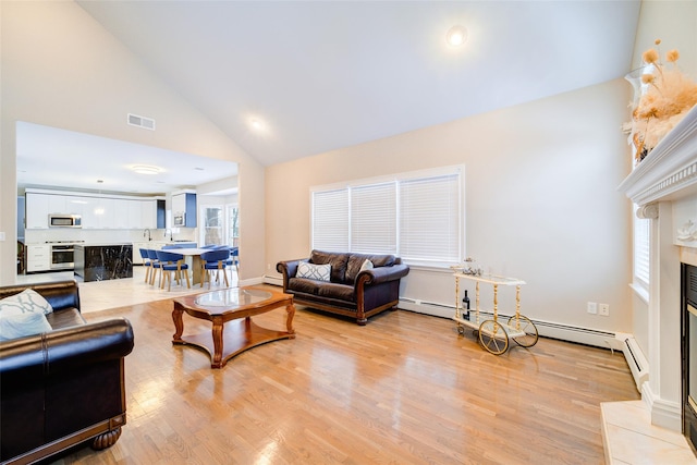 83 N Airmont Rd, Suffern, NY 10901 - living area with a fireplace with raised hearth, high vaulted ceiling, light wood-type flooring, and baseboard heating