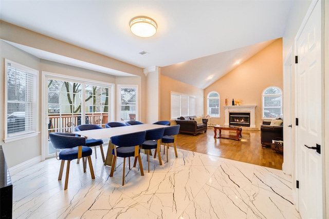 83 N Airmont Rd, Suffern, NY 10901 - dining room with marble tiled floors, lofted ceiling, and a warm lit fireplace