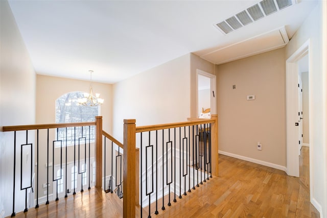 83 N Airmont Rd, Suffern, NY 10901 - hall with an upstairs landing, light wood-type flooring, a chandelier, and attic access