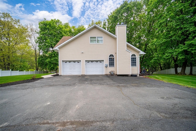 83 N Airmont Rd, Suffern, NY 10901 - view of home's exterior featuring driveway, a chimney, and an attached garage