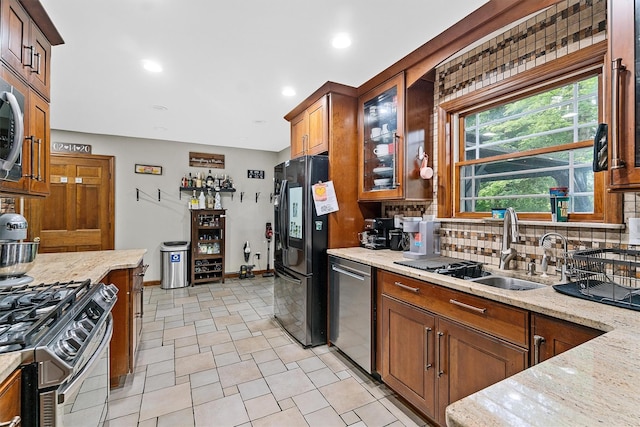 9 Schnabl Ct, Wappingers Falls, NY 12590 - kitchen with appliances with stainless steel finishes, backsplash, glass insert cabinets, brown cabinets, and light stone counters