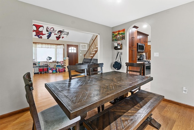 9 Schnabl Ct, Wappingers Falls, NY 12590 - dining space featuring light wood-style flooring, stairs, and arched walkways