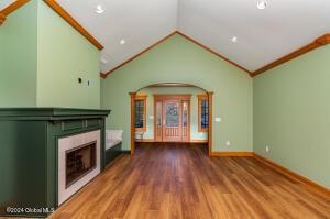138 Lydon Ln, Hannacroix, NY 12124 - unfurnished living room with a fireplace, vaulted ceiling, crown molding, wood finished floors, and recessed lighting
