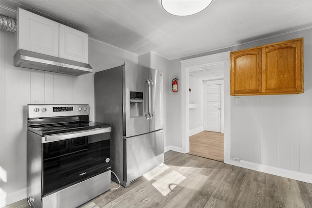 5 Putnam Ter, Brewster, NY 10509 - kitchen with appliances with stainless steel finishes, range hood, light wood-style floors, and brown cabinets