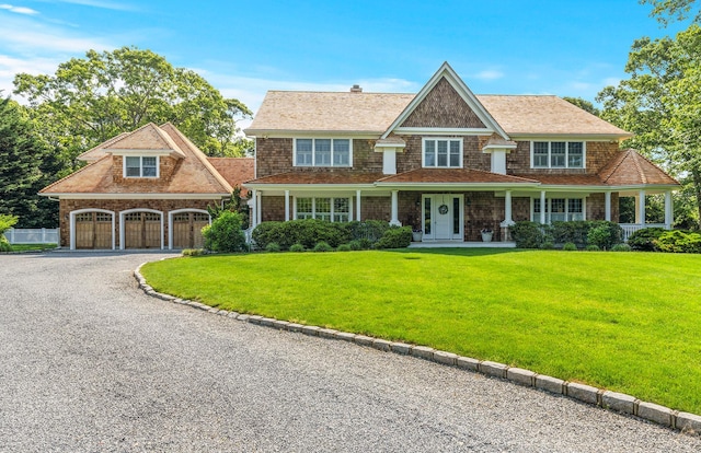 1 Simon Ct, Quogue, NY 11959 - shingle-style home with a porch, driveway, and a front lawn
