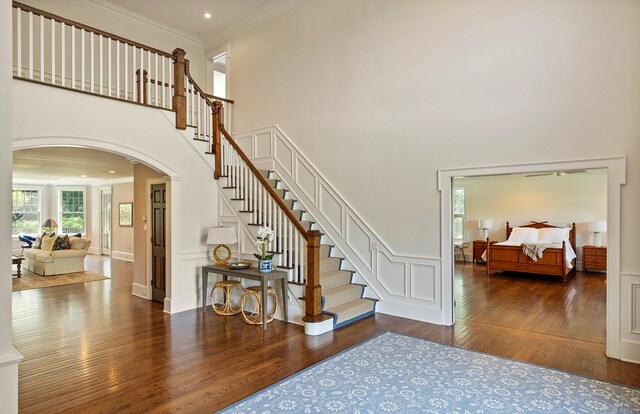 1 Simon Ct, Quogue, NY 11959 - foyer with arched walkways, wood finished floors, crown molding, a towering ceiling, and stairway