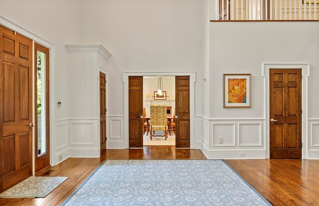 1 Simon Ct, Quogue, NY 11959 - foyer entrance featuring wood finished floors, a decorative wall, a towering ceiling, and a wainscoted wall