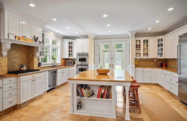 1 Simon Ct, Quogue, NY 11959 - kitchen featuring appliances with stainless steel finishes, crown molding, recessed lighting, stone tile flooring, and decorative backsplash