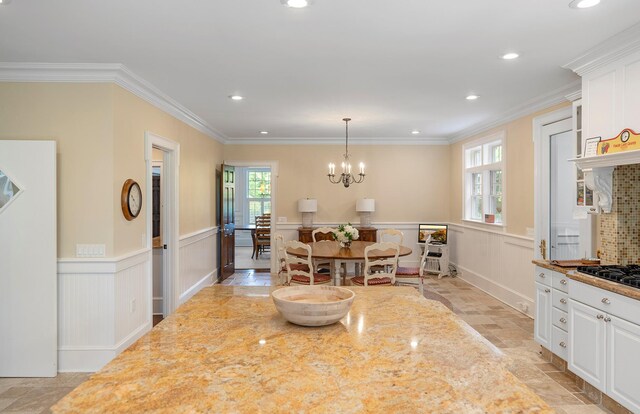 1 Simon Ct, Quogue, NY 11959 - dining space featuring a decorative wall, light stone finish floors, a chandelier, a wainscoted wall, and recessed lighting