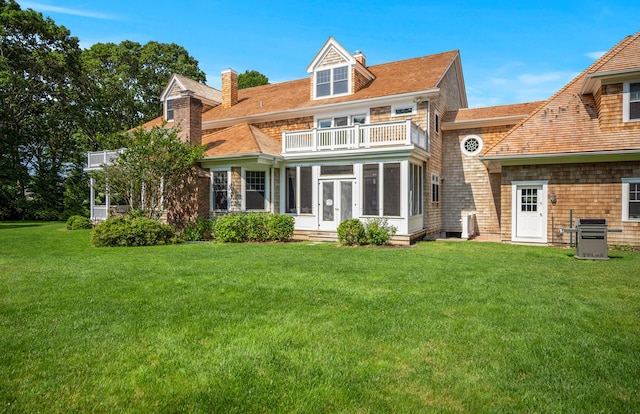 1 Simon Ct, Quogue, NY 11959 - rear view of property featuring a balcony, a sunroom, a chimney, and a yard