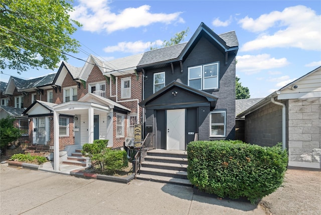 13015 Sutter Ave, South Ozone Park, NY 11420 - view of front facade featuring brick siding, roof with shingles, and a residential view