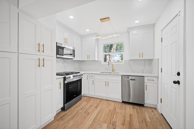 13015 Sutter Ave, South Ozone Park, NY 11420 - kitchen with stainless steel appliances, light countertops, white cabinets, light wood-style floors, and recessed lighting