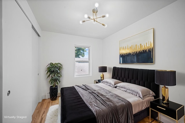 13015 Sutter Ave, South Ozone Park, NY 11420 - bedroom with a chandelier, wood finished floors, and a closet