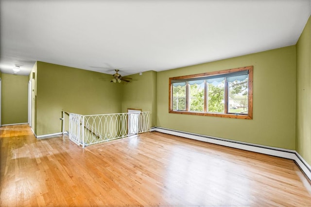 1291 Minerva Ave, West Islip, NY 11795 - empty room featuring baseboard heating, wood finished floors, and ceiling fan