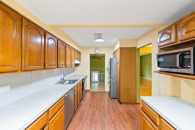 1291 Minerva Ave, West Islip, NY 11795 - kitchen with stainless steel appliances, light countertops, dark wood-type flooring, and brown cabinets