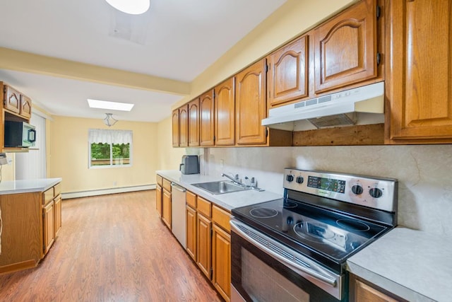 1291 Minerva Ave, West Islip, NY 11795 - kitchen with appliances with stainless steel finishes, under cabinet range hood, a baseboard heating unit, light wood-style floors, and brown cabinetry
