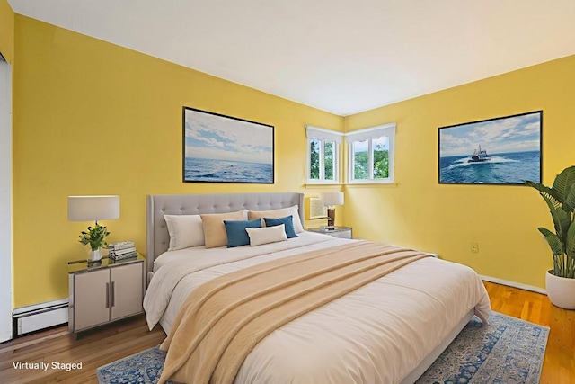 1291 Minerva Ave, West Islip, NY 11795 - bedroom featuring a baseboard radiator and wood finished floors