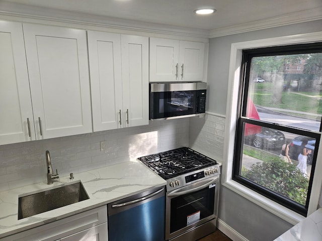 300 Richbell Rd Unit B2, Mamaroneck, NY 10543 - kitchen featuring stainless steel appliances, light stone countertops, white cabinets, decorative backsplash, and ornamental molding