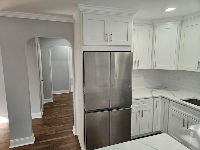 300 Richbell Rd Unit B2, Mamaroneck, NY 10543 - kitchen with freestanding refrigerator, crown molding, arched walkways, light stone countertops, and white cabinets