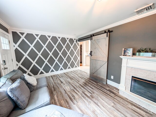 14 Hampton Rd, Sound Beach, NY 11789 - unfurnished living room featuring ornamental molding, wood finished floors, a barn door, and a stone fireplace