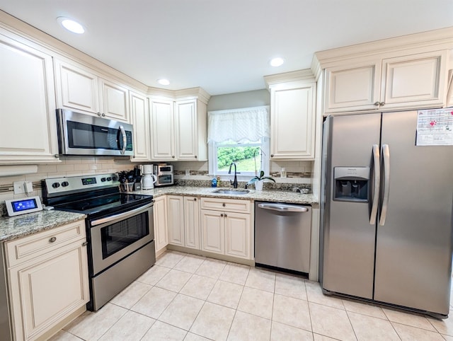 14 Hampton Rd, Sound Beach, NY 11789 - kitchen with appliances with stainless steel finishes, cream cabinetry, light stone countertops, backsplash, and recessed lighting